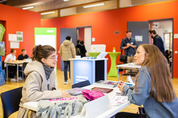 Gespräch auf der Messe Zwei Frauen sitzen an einem Tisch und unterhalten sich