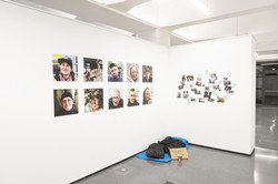 Fotofestival f² Eine Installation der Ausstellung zeigt einen Schlafsack und eine dünne Matratze auf dem Boden. Darüber hängen Portraitfotos verschiedener Obdachloser.