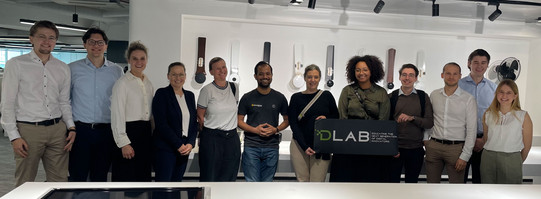 Gruppe von Personen bei einem Besuch im DLAB, moderne Ausstellung im Hintergrund.