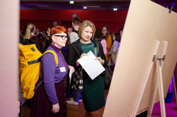 Two people look at a poster