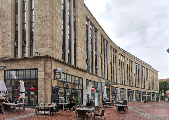 Kaufhaus in Gelsenkirchen. Vor dem Kaufhaus ist eine Außenterrasse mit Tischen und Stühlen.