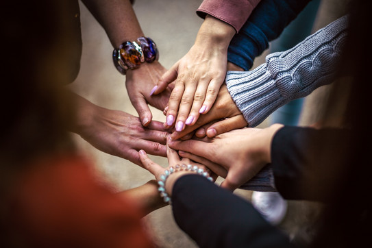 Hands_Teamwork Several hands belonging to different people are lying on top of each other.