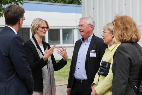 Ministerin Karliczek besucht ML2R_1 Drei Frauen und zwei Männer stehen vor einer Versuchshalle und unterhalten sich