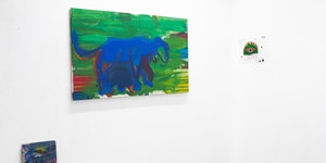 Drei Kunstwerke der Kunst AG Ausstellung an einer weißen Wand.