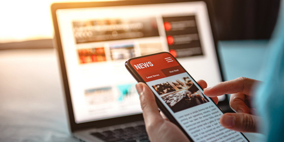 News is displayed on a laptop and a cell phone