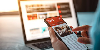 News is displayed on a laptop and a cell phone