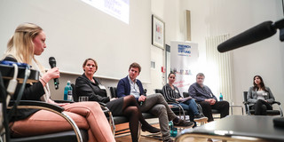 Podiumsdiskussion_Journalismus Sechs Personen sitzen auf einer Bühne und sprechen miteinander.
