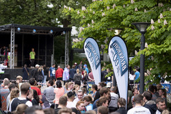 in the background a stage, in front of it many people