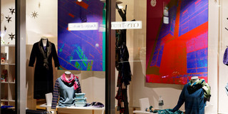 Geguckt in Dortmund _ Kunst im Schaufenster Im Schaufenster eines Modegeschäfts hängen große Fotografien von Häuserfassaden, die mit einem Farbfilter bearbeitet wurden.