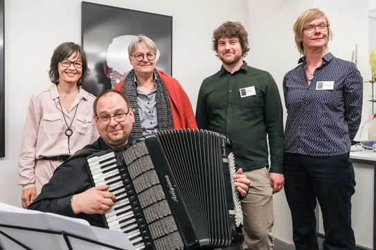 Gruppenfoto von drei Frauen und zwei Männern, einer von ihnen hält ein Akkordeon