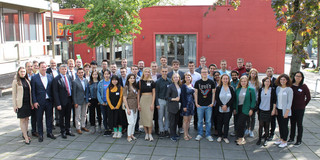 Group photo in front of red building