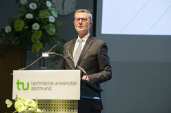Mann steht am Rednerpult