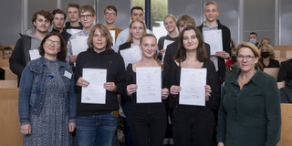 SchülerUni 2022 Gruppenfoto von Schüler*innen, die Urkunden in die Kamera halten.