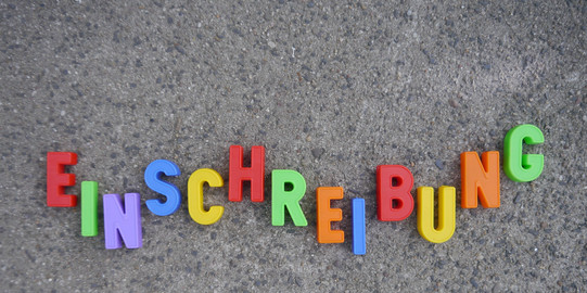 Schriftzug Einschreibung aus einzelnen Buchstaben auf Steinboden. 