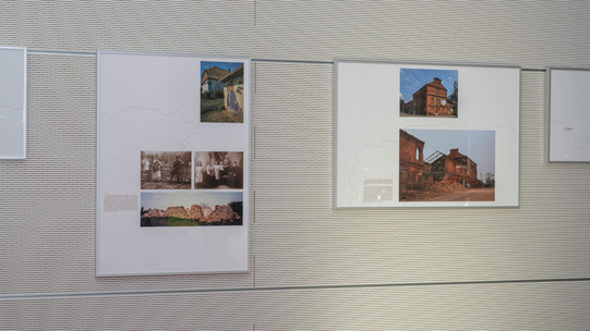 Foto: Gerahmte Fotografien und Texte hängen als Teil einer Ausstellung an einer Wand.
