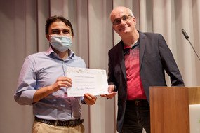 Professor Manfred Bayer hands visiting scholar his certificate.