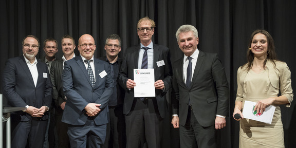 Exzellenz Start-up Center TU Dortmund Gruppenfoto, ein Mann hält eine Urkunde in den Händen