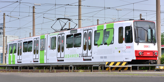 Gedankenzüge Eine U-Bahn in weiß auf der Zitate des Projekts Gedankenzüge abgebildet sind.