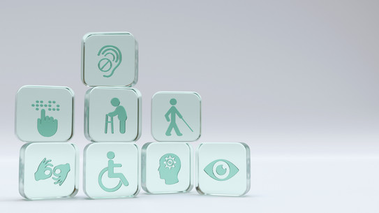 Sieben türkisfarbene Würfel mit Symbolen für Behinderungen und Barrierefreiheit, darunter ein Ohr mit Hörgerät, eine Person mit Rollator, eine Person mit Blindenstock, Gebärdensprache, Rollstuhl, Kopf mit Zahnrad und ein Auge. 3D-Rendering.