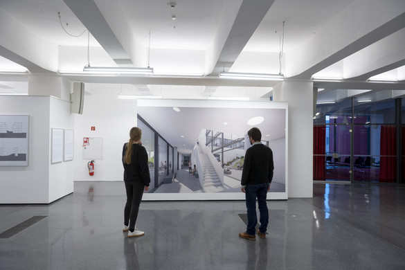 Zwei Personen sind in einer Ausstellung und betrachten ein Bild an einer weißen Wand.