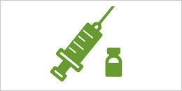 Symbolbild mit Spritze und Impfstoff-Ampulle.