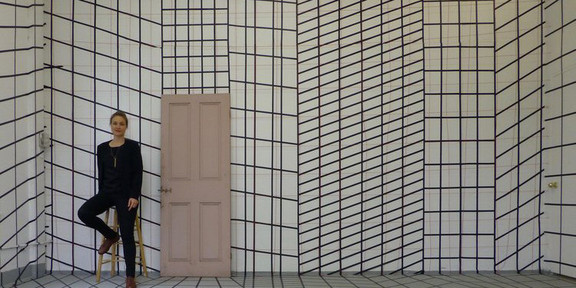 Kaemmerling Porträt von Astrid Kämmerling in einem Raum mit schwarz-weiß gemusterter Tapete.