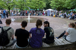 Viele Personen sitzen um einen Brunnen herum