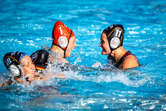 Foto: Zwei Wasserballspielerinnen jubeln sich im Wasser zu.