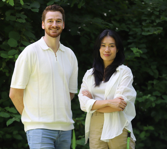 Der Berater trägt ein weißen T-Shirt und eine blaue Jeans. Die Beraterin trägt ein weißen Oberteil und eine cremefarbene Hose. 