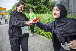 eine Frau übergibt den Stab an eine andere