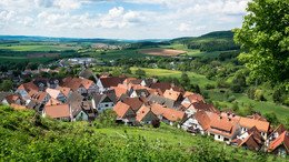 Ein Dorf in einer grünen Landschaft mit blauem Himmel