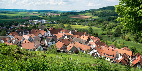 Ein Dorf in einer grünen Landschaft mit blauem Himmel