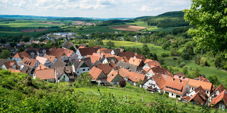 Ein Dorf in einer grünen Landschaft mit blauem Himmel