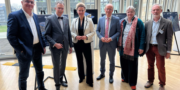 Gruppenfoto im Landtag NRW: Von links nach rechts sind TU-Rektor Prof. Manfred Bayer, Ernst Uhing, Präsident der Architektenkammer NRW, NRW-Kulturministerin Ina Brandes, Landtagspräsident André Kuper, Prof. Barbara Welzel und Prof. Wolfgang Sonne abgebildet.