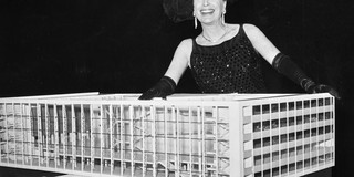 A black and white photo of a woman behind the model of a musical theater