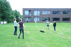 Teilnehmer spielen auf einer Wiese Federball