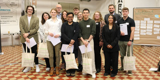 Smash_Abschlussveranstaltung Zu sehen ist das Siegerteam der Smash the Box Challange in einer Halle mit hohen Decken