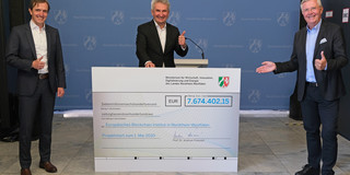 Grant agreement Three smiling men in suits standing next to each other