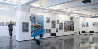 Ein Foto von einem Ausstellungsraum mit weißen Wänden und vielen Fotografien.