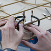 Detail of hands measuring an angle in a wooden model.