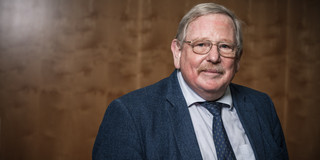 Portrait eines älteren Herren (Prof. Reinhard Genzel) mit Brille, Anzug und Krawatte.