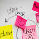 Symbolbild Workshop Bunte beschriftete Klebezettel sind an einem Whiteboard angebracht.