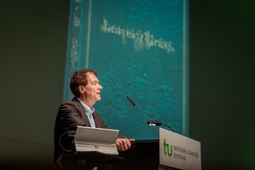 Prof. Grünzweig an einem Sprecherpult, im Hintergrund das Cover der Erstausgabe Whitmans