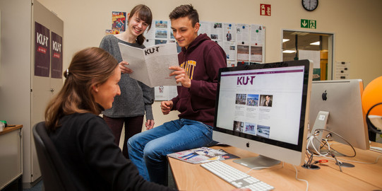Zwei Weibliche und ein männlicher Student der Lehrredaktion KURT in einer Arbeitssituation