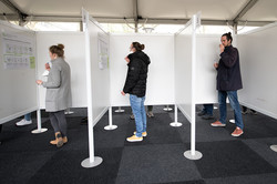 View into three test booths with students currently performing a Corona self-test