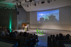 Audimax vollbesetztes Audimax mit Blick auf die Bühne, in der Präsentation wird ein Teleskop gezeigt