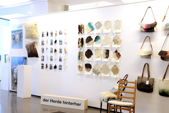 Auf dem Foto sieht man verschiedene Ausstellungsstücke vor einer weißen Wand stehen und hängen.