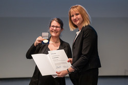 Two people hold up a certificate.