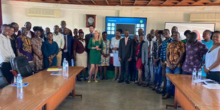 Projektauftakt für CoMMPASS in Kampala, Uganda Eine große Gruppe afrikanischer und europäischer Wissenschaftler*innen steht halbkreisförmig in einem Konferenzraum, der Kamera zugewandt.