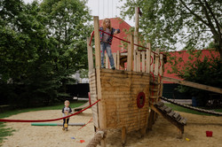 A girl is standing on the pirate ship.
